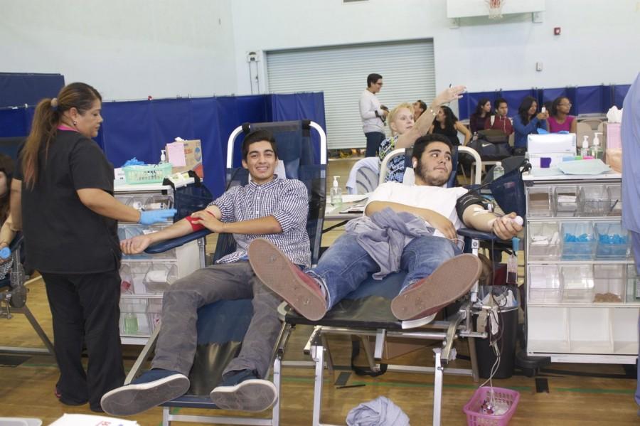 Two students donating blood at the blood drive.