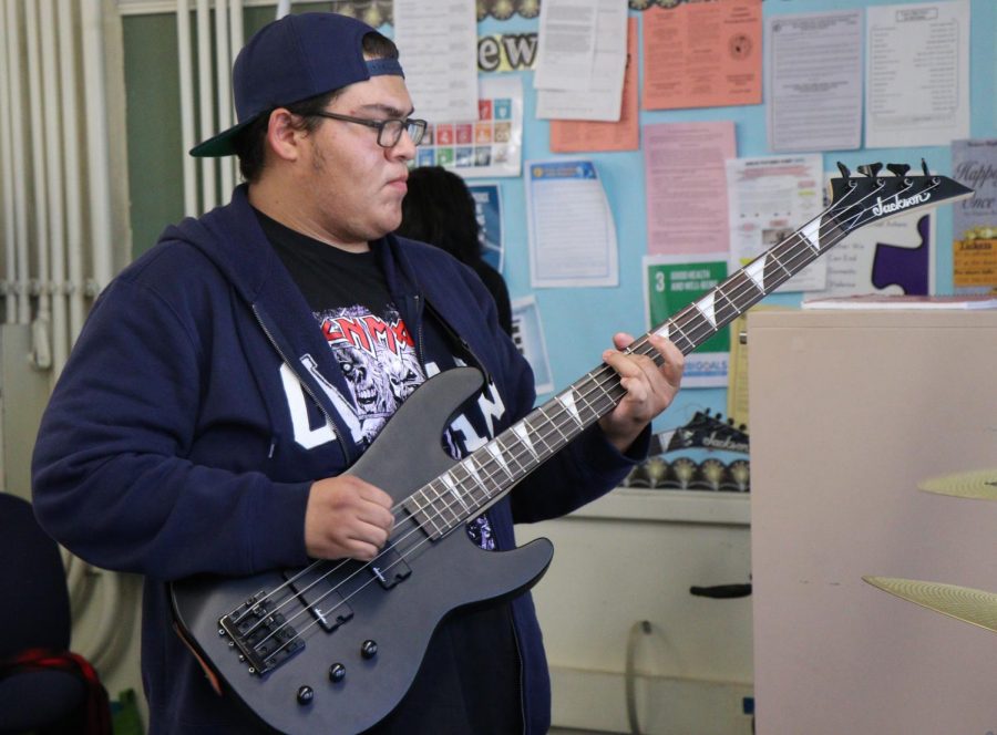 Bassist plays during Rock Band Club practice.