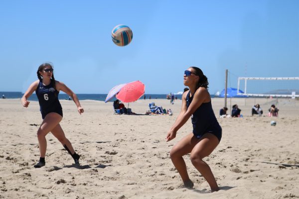Socks in the sand: Juniors Adalaide Groff and Savannah Rozell recieves the ball during a tournament, April 6.
