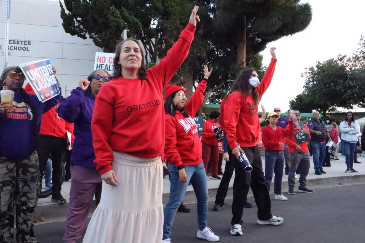Hands raised high: Math teacher Jessica Quindel, Spanish teacher Maria Lopez Zamudio, and social studies teacher Taylor Vivanco partake in a dance that raise union spirits at a regional UTLA rally November 6.