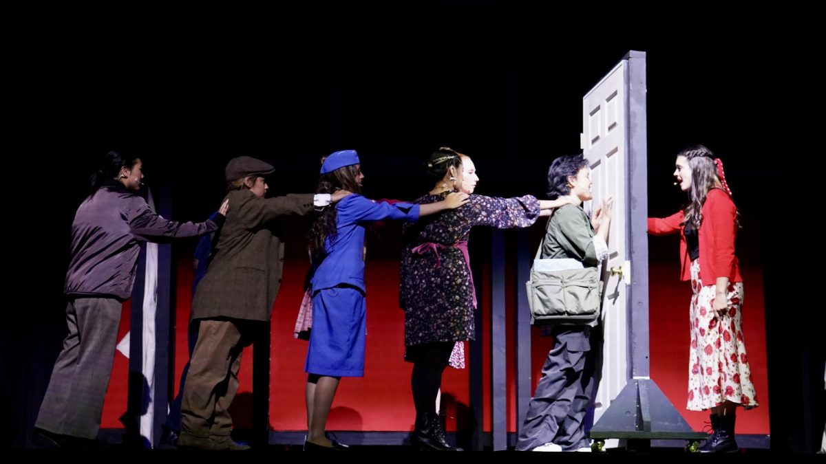 Reaching out: The ensemble of Amélie (Senior Jennifer Rolston, freshman Kalea Jade, freshman Una Watkins, junior Sofia Luz Jimenez, sophomore Taylor Gallen, junior Toby Bernov, and junior Shayden Satuloff) create a visual representation of disconnection in the May 22 performance.