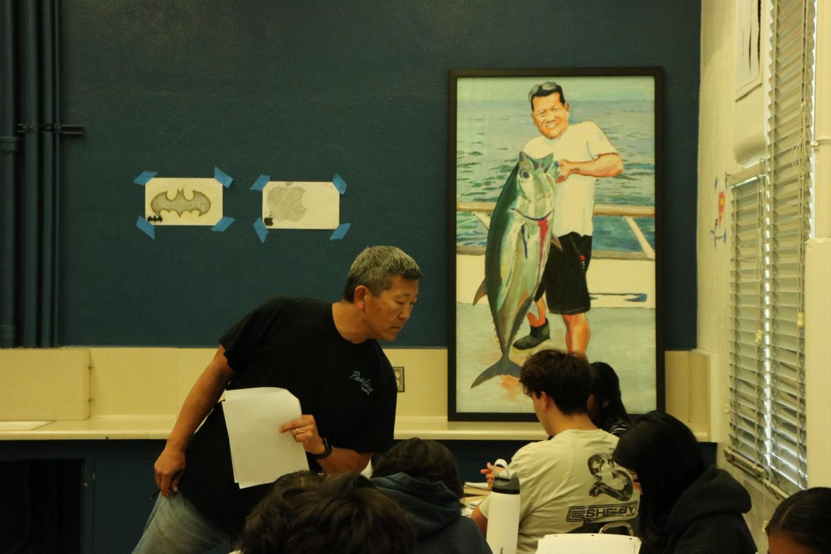 A-grade on the war: Math teacher Walter Fujita checks answers around his classroom in the East Building May 28.